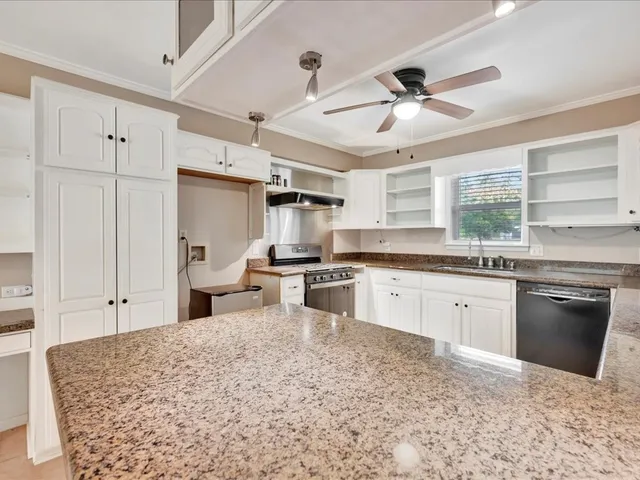 a kitchen with granite countertop a sink stainless steel appliances and counter space