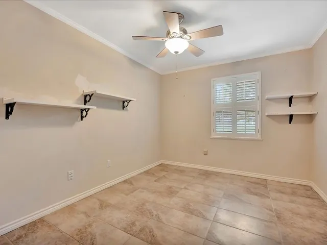 a view of a room with a ceiling fan and a window