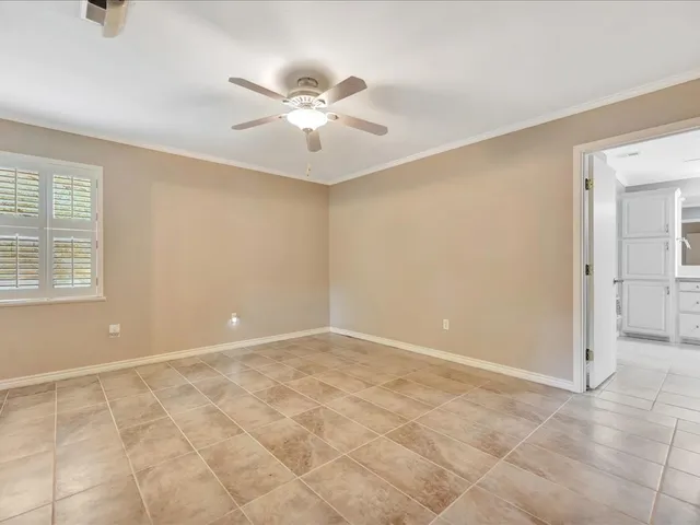 an empty room with fan and windows