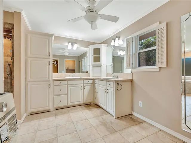 a spacious bathroom with a granite countertop sink mirror and a bathtub
