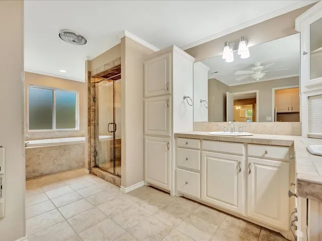 a spacious bathroom with a shower a sink and a mirror