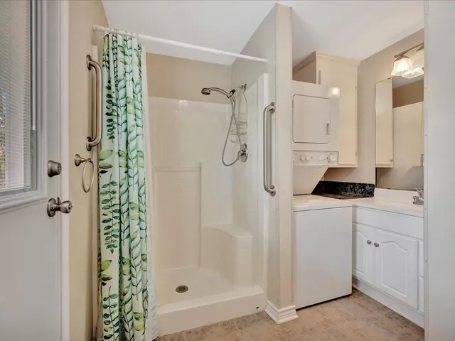 a bathroom with a shower a sink and a mirror