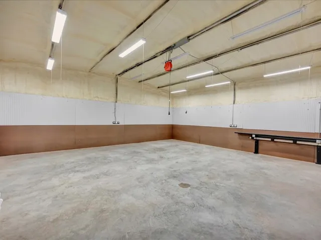 an empty room with projector and windows