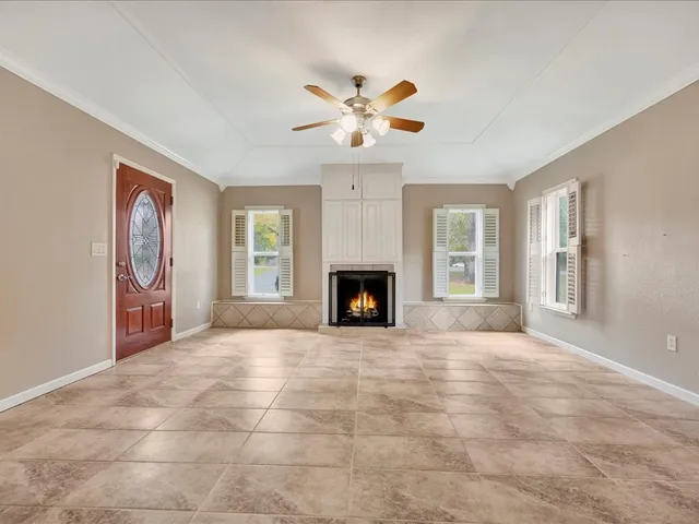 a view of an empty room with window and fireplace