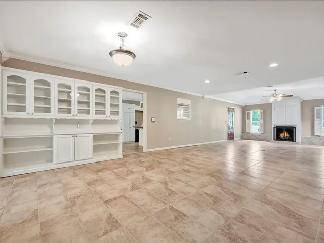 a view of an empty room with a window and a kitchen