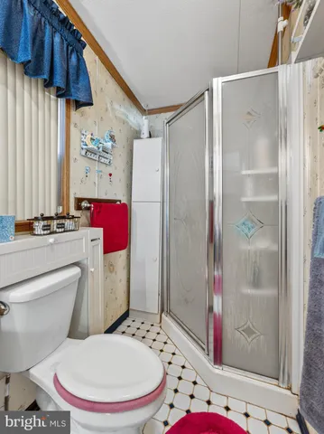 a white toilet sitting next to a bathroom sink and shower