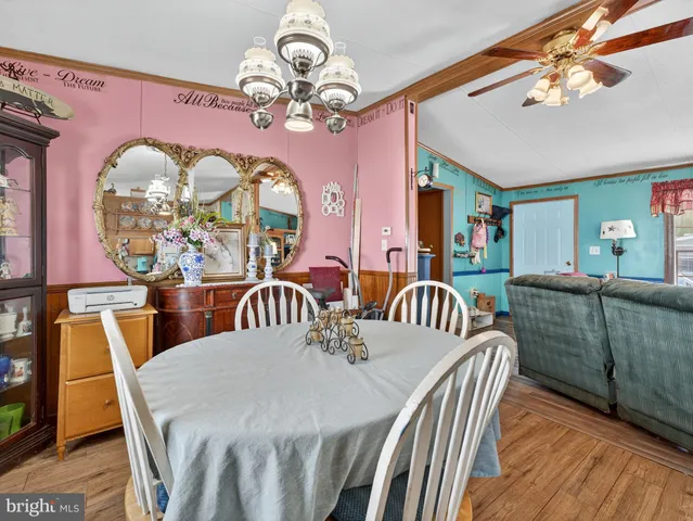a view of a dining room with furniture a chandelier and wooden floor