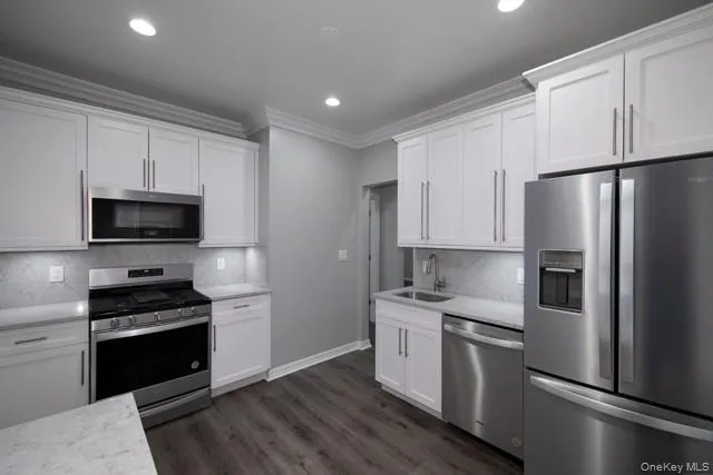 a kitchen with white cabinets and stainless steel appliances