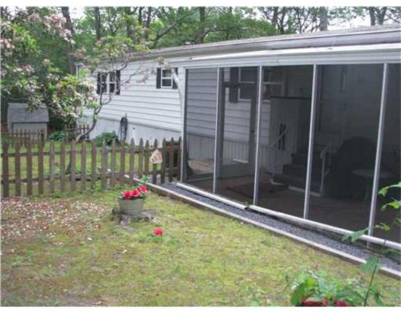 301 Bulgarmarsh Road, Unit T 76 Tiverton, RI 02878 - Photo 2 of 8 a view of backyard with tub and wooden fence