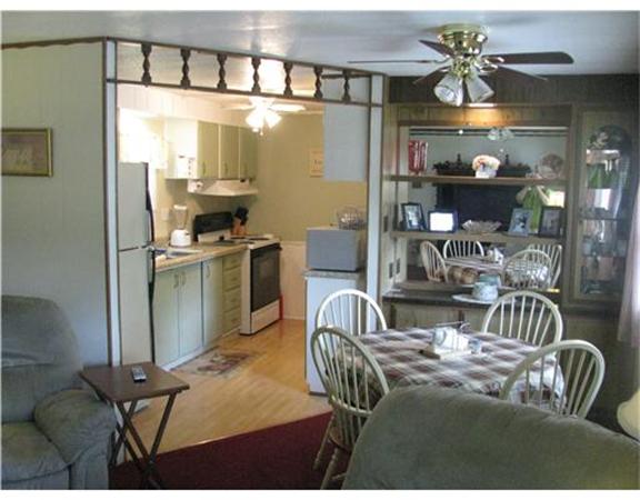 301 Bulgarmarsh Road, Unit T 76 Tiverton, RI 02878 - Photo 3 of 8 a living room with furniture and a chandelier