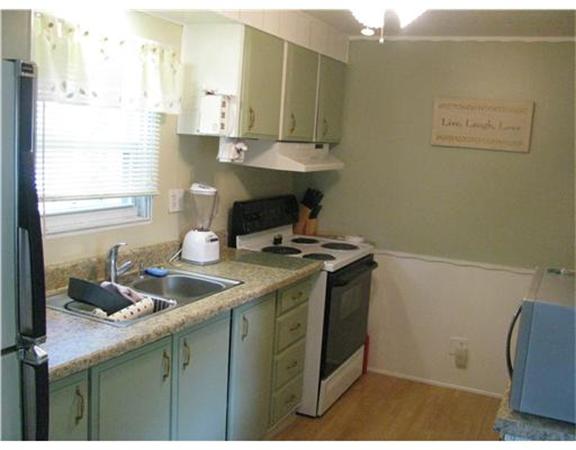 301 Bulgarmarsh Road, Unit T 76 Tiverton, RI 02878 - Photo 4 of 8 a kitchen with a sink cabinets and window