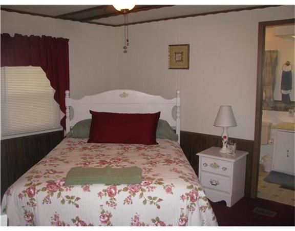 301 Bulgarmarsh Road, Unit T 76 Tiverton, RI 02878 - Photo 5 of 8 a bedroom with a bed and a dresser
