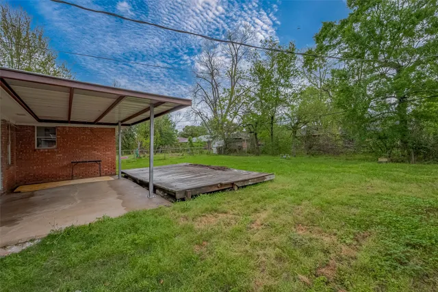 a view of a backyard with table and chairs under an umbrella