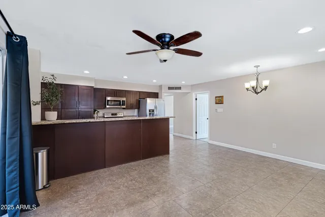 a kitchen with kitchen island white cabinets and refrigerator