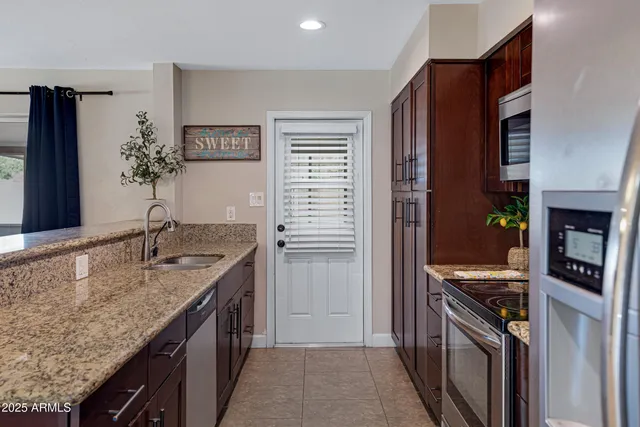 a kitchen with stainless steel appliances granite countertop a sink stove and refrigerator