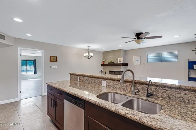 a kitchen with granite countertop a sink and a refrigerator