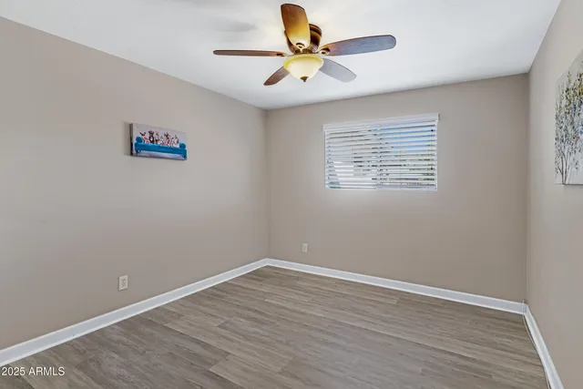 a view of room with hardwood floor and ceiling fan
