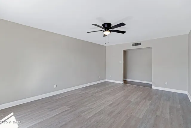 a view of room with wooden floor ceiling fan and window