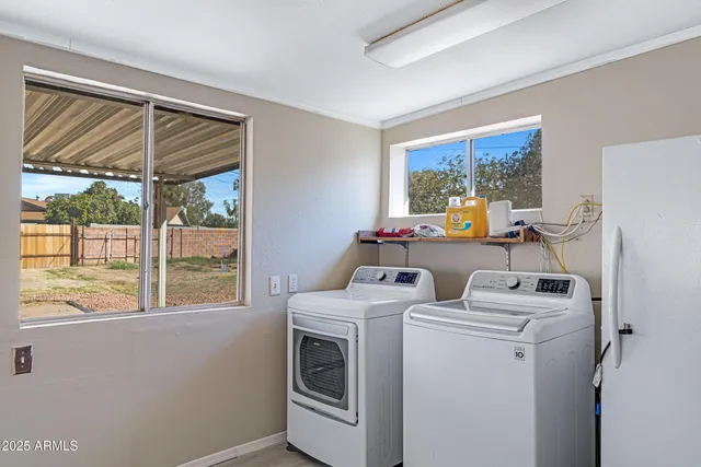 a view of washer and dryer with bathroom in the background