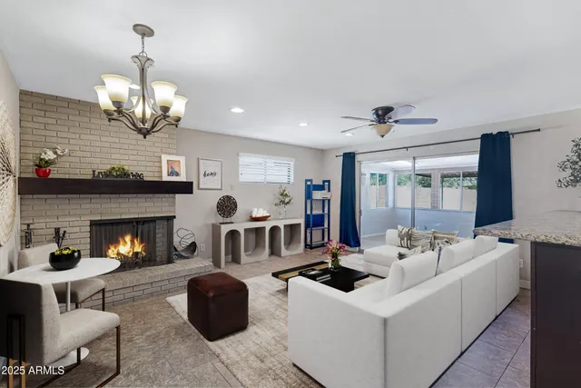 a living room with furniture a fireplace and a chandelier