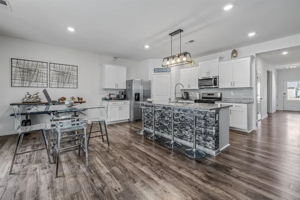 a kitchen with stainless steel appliances kitchen island granite countertop a sink and cabinets