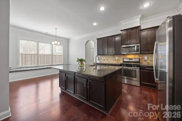 a kitchen with stainless steel appliances granite countertop a stove a sink and a refrigerator