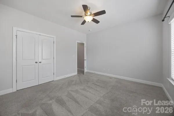 an empty room with a ceiling fan and a window