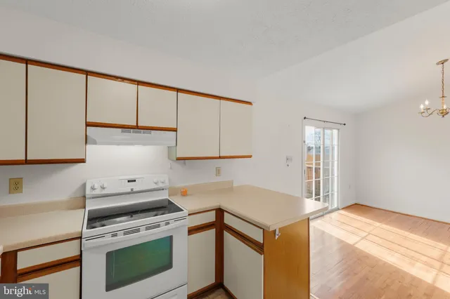 a kitchen with a stove cabinets and a window