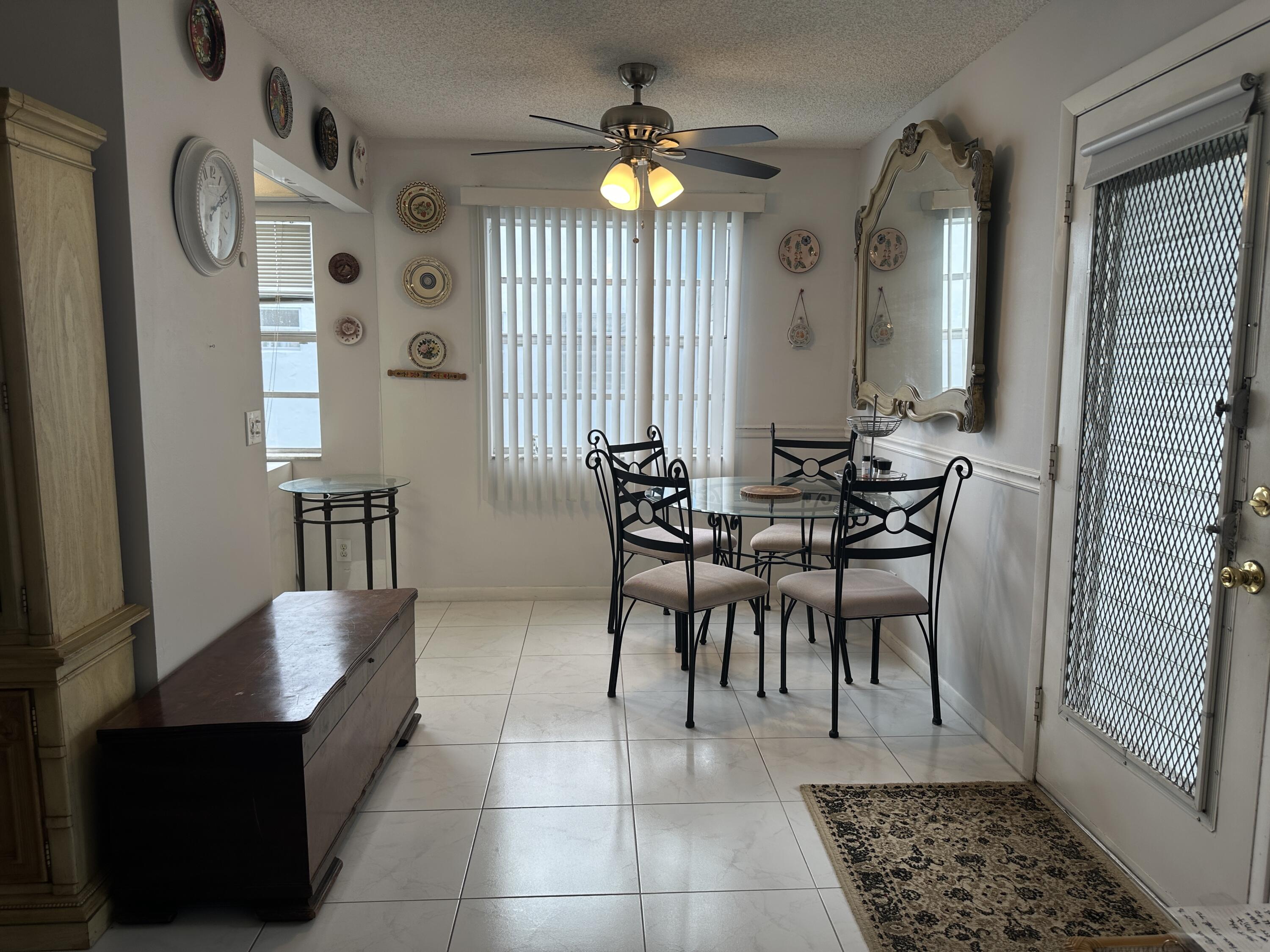 415 Saxony Way Delray Beach, FL 33446 - Photo 4 of 23 a dining room with furniture and a chandelier fan
