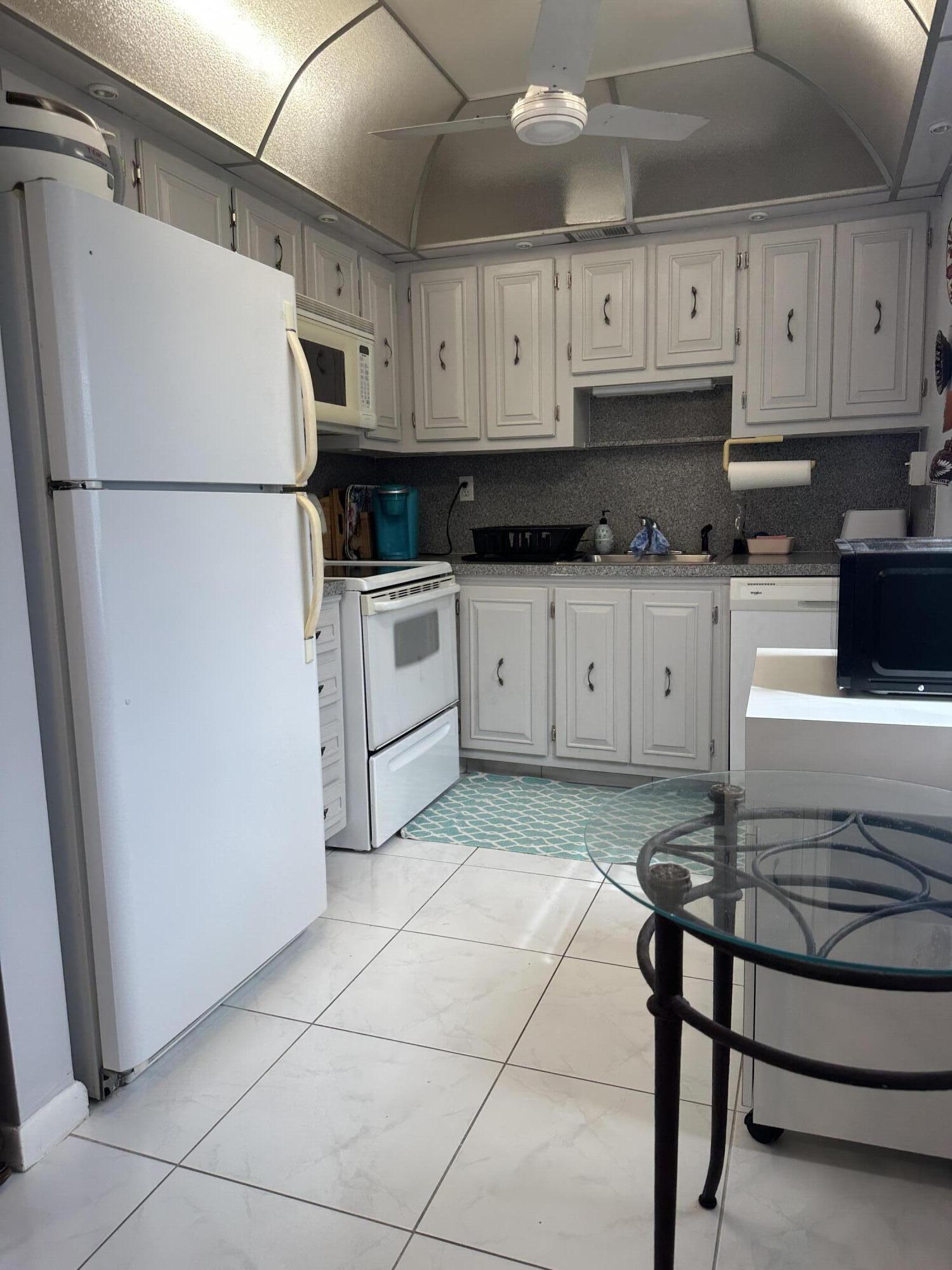 415 Saxony Way Delray Beach, FL 33446 - Photo 5 of 23 a kitchen with stainless steel appliances granite countertop a refrigerator sink and cabinets