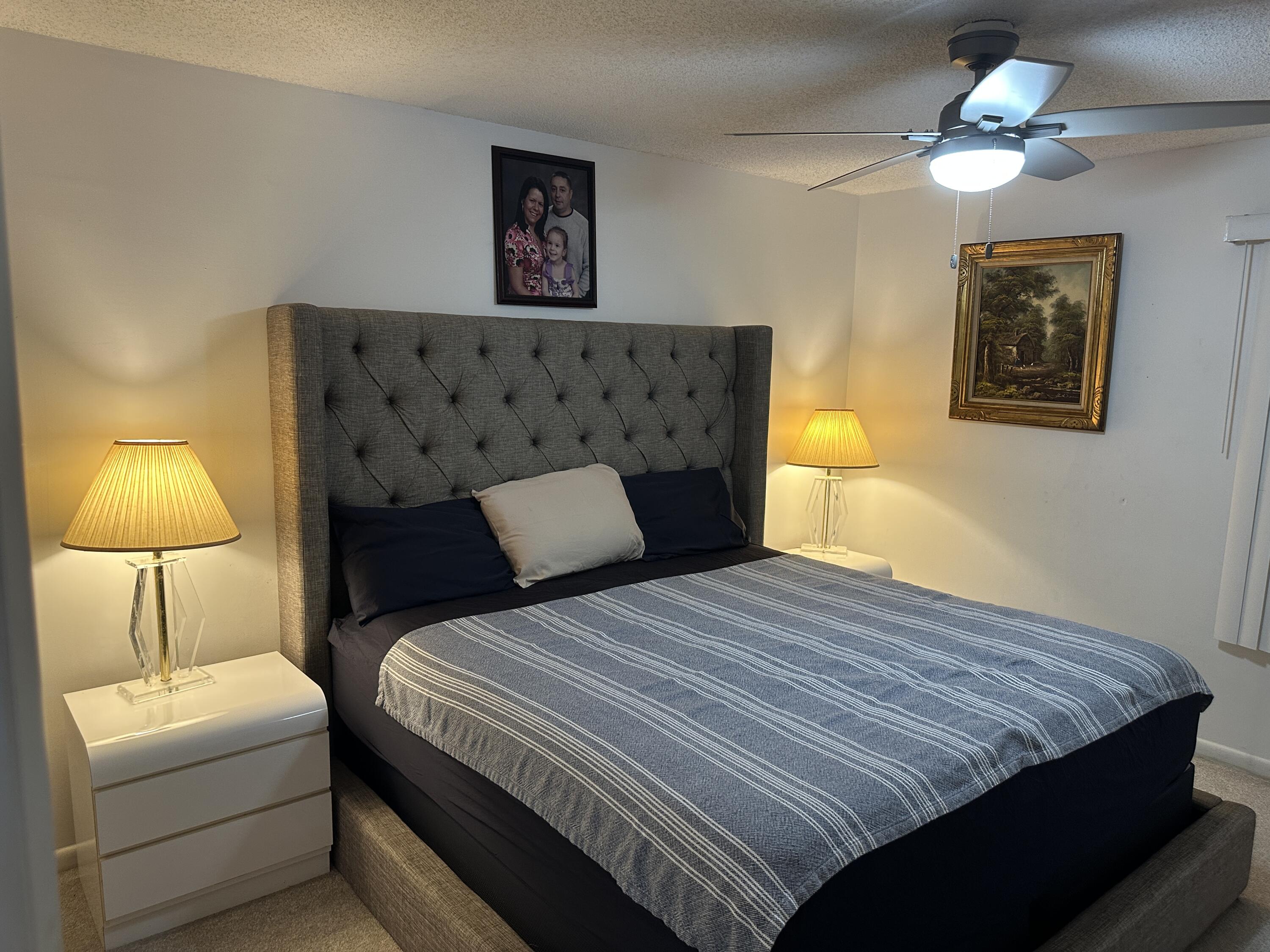 415 Saxony Way Delray Beach, FL 33446 - Photo 6 of 23 a bedroom with a bed and a chandelier