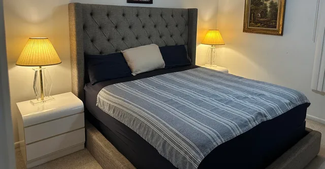 a bedroom with a bed and lamp with the wall