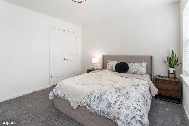 a bedroom with a bed and a potted plant