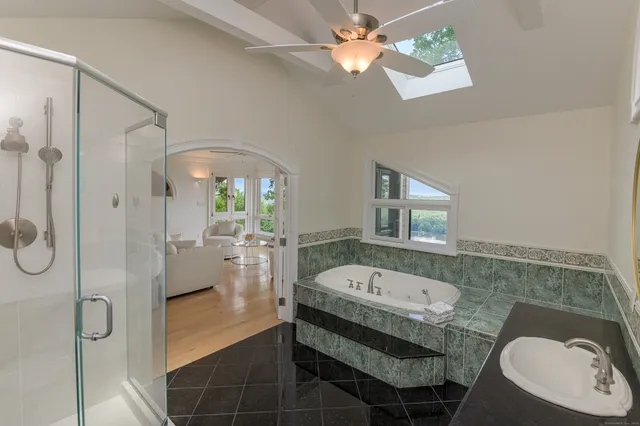 a bathroom with a sink a mirror a bathtub and shower