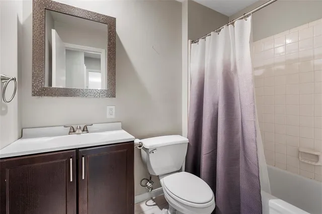 a bathroom with a sink a toilet and shower curtain