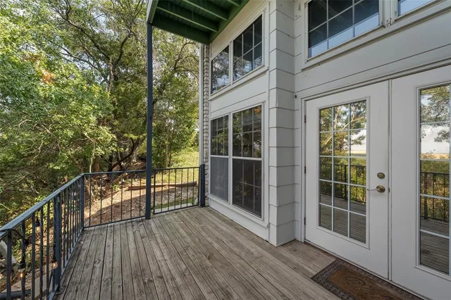 a view of a balcony with wooden floor and fence
