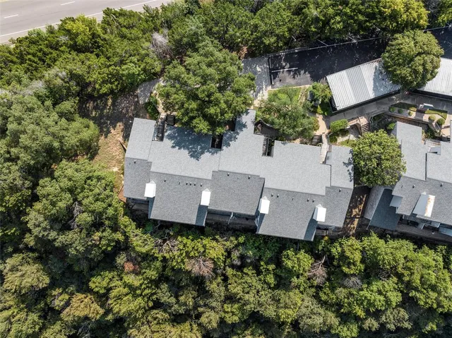 an aerial view of a house with a yard and tree s