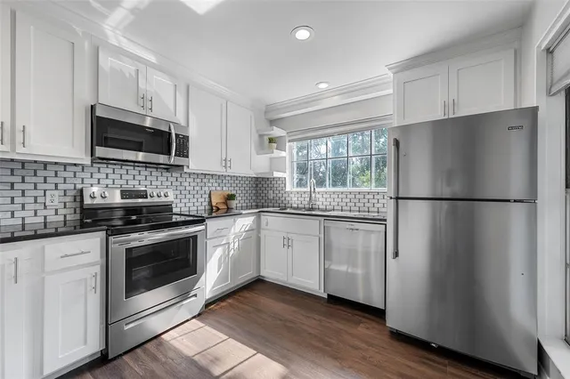 a kitchen with stainless steel appliances granite countertop a refrigerator stove a sink and a microwave