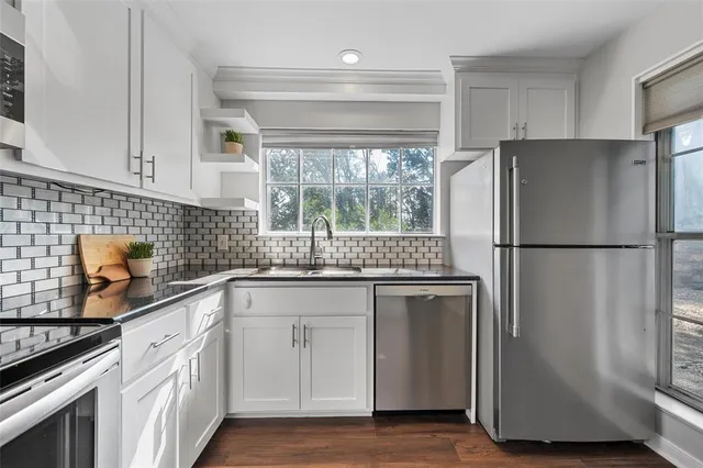 a kitchen with stainless steel appliances granite countertop a refrigerator sink and cabinets