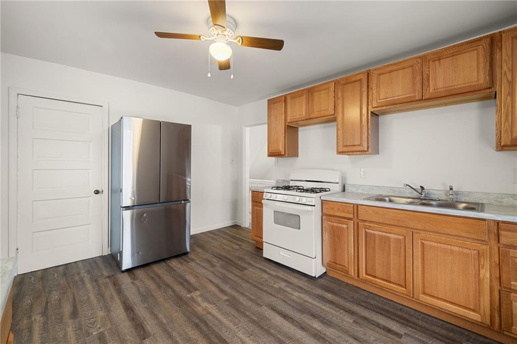 62 Maytide Street Pittsburgh, PA 15227 - Photo 15 of 23 a kitchen with granite countertop a refrigerator a stove and white cabinets