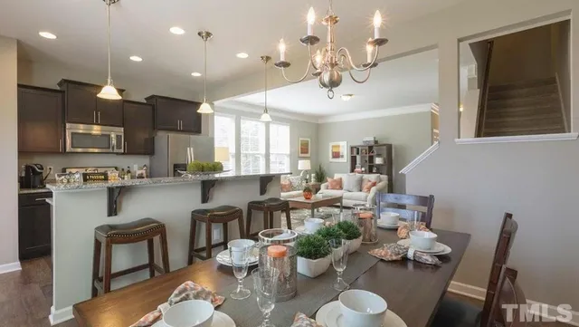 a living room with furniture kitchen view and a chandelier