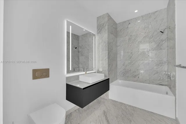 a bathroom with a bathtub shower sink and toilet