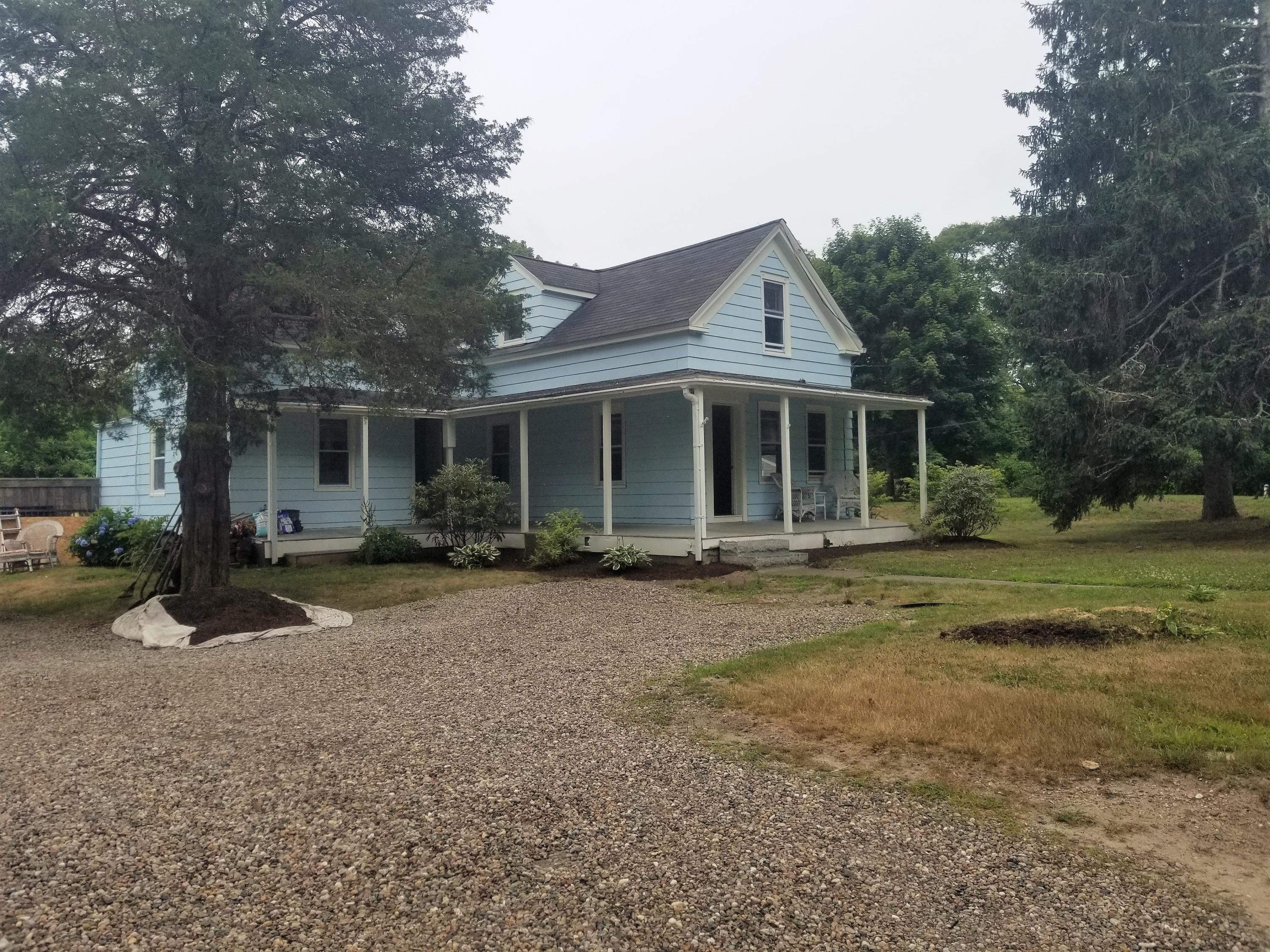 a view of a house with a yard and large tree