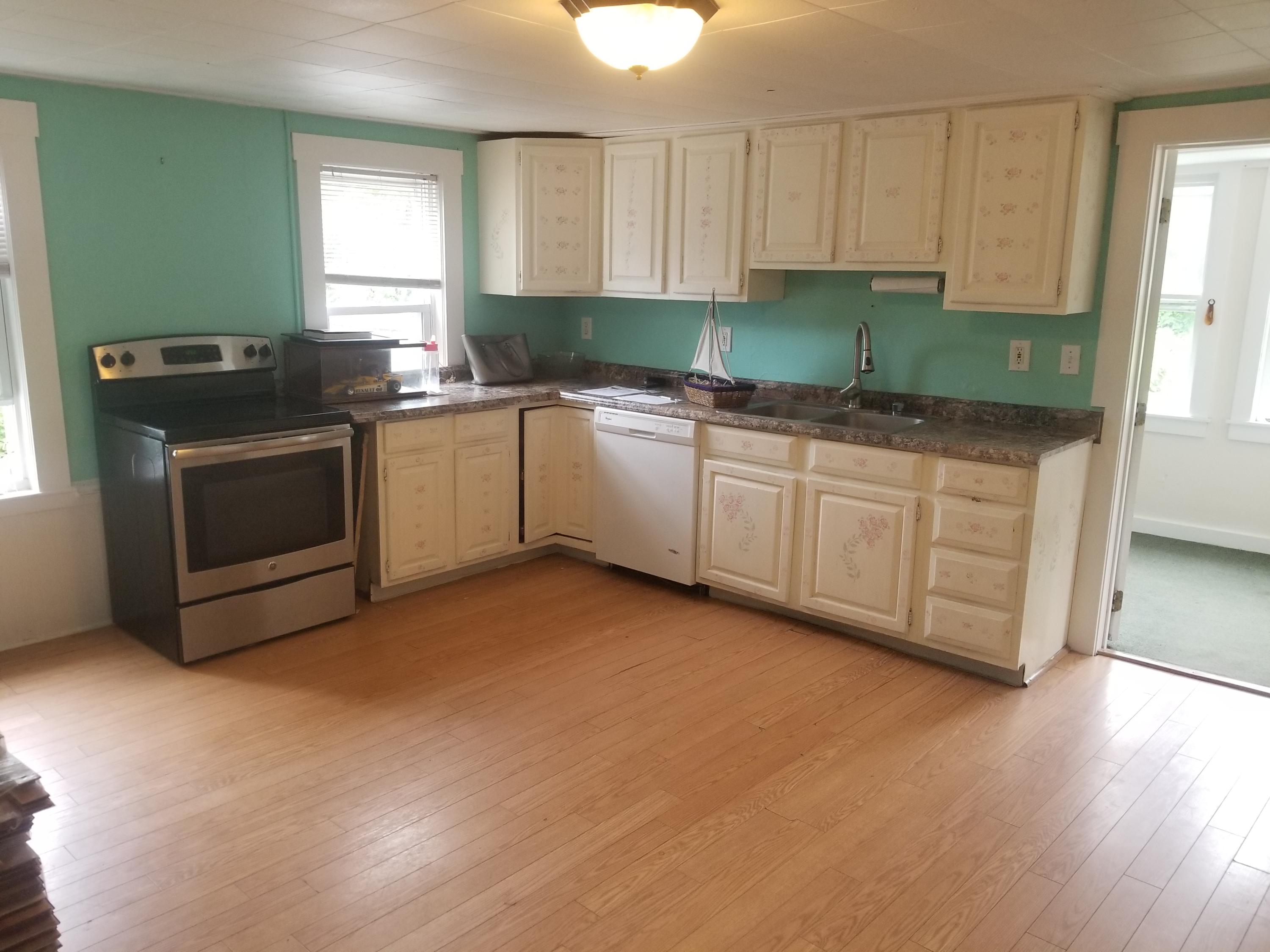 85 Shore Road Bourne, MA 02532 - Photo 4 of 16 a kitchen with granite countertop a stove a sink and a microwave