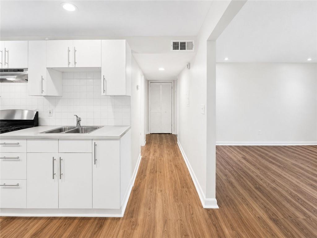 3193 East Point Street, Unit 4 Atlanta, GA 30344 - Photo 10 of 20 a kitchen with granite countertop white cabinets and wooden floor