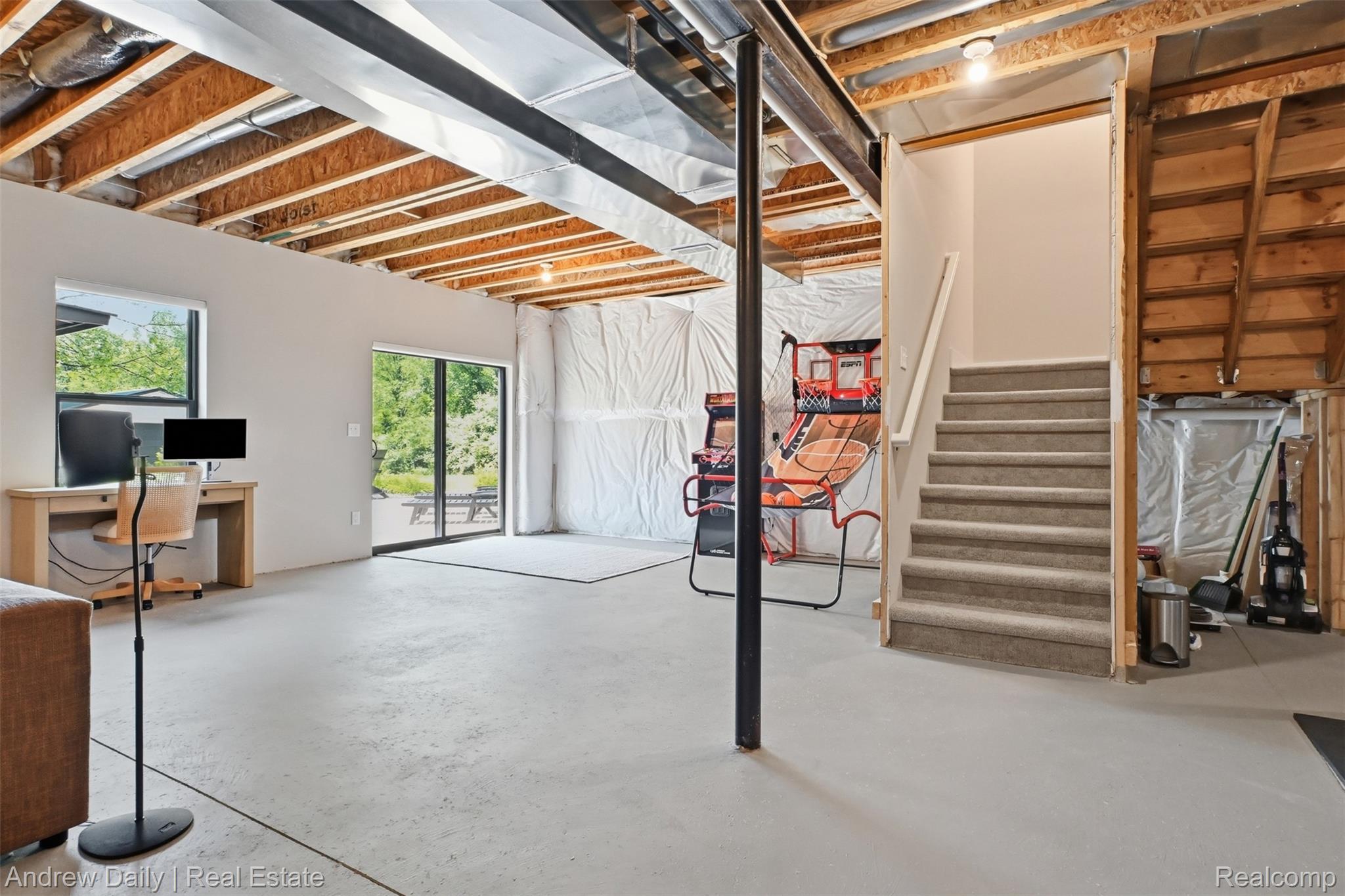 4661 Spears Road Pinckney, MI 48169 - Photo 40 of 56 Finished concrete flooring, exposed wood joists, and a full-light sliding glass door leading to an outdoor patio