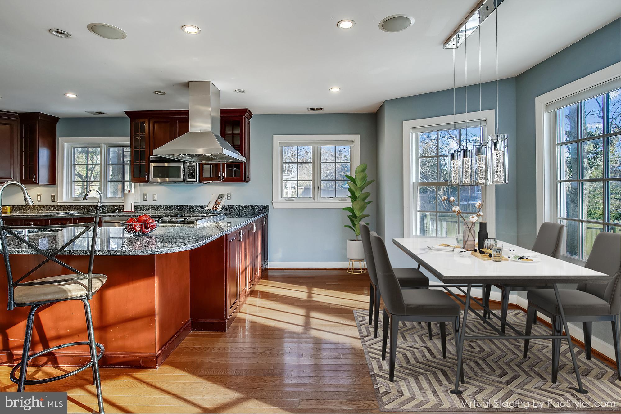 4664 Reservoir Road Northwest Washington, DC 20007 - Photo 6 of 60 a kitchen with stainless steel appliances granite countertop a stove top oven a sink a dining table and chairs with wooden floor