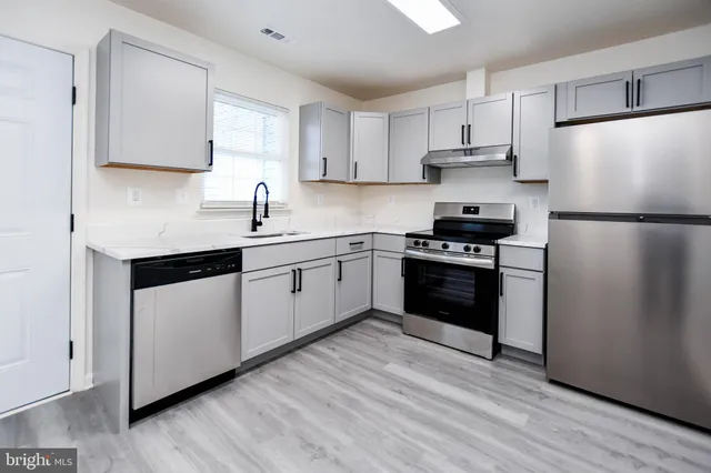 a kitchen with white cabinets and white appliances