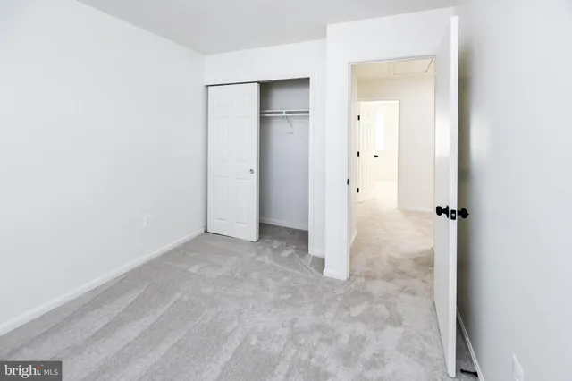 an empty room with closet and a bathroom
