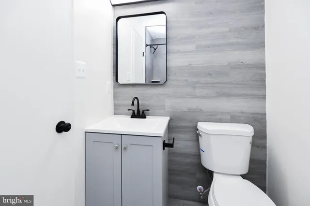 a bathroom with a toilet sink and mirror